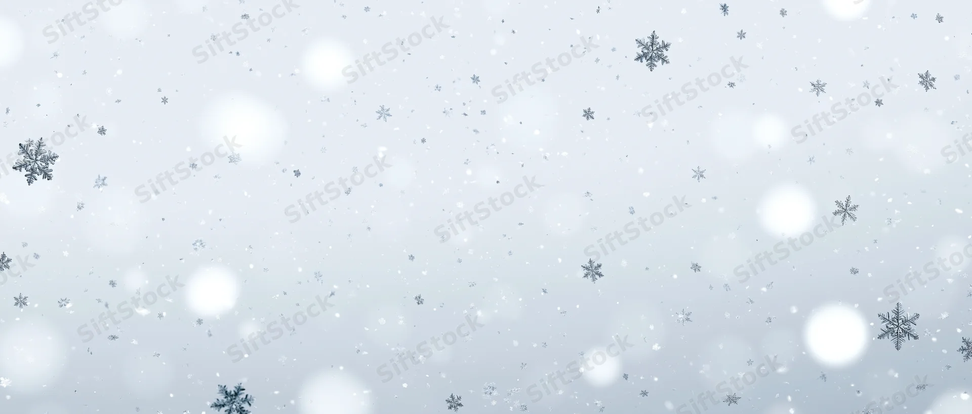 Falling snowflakes and soft bokeh particles scattered across a light gray background