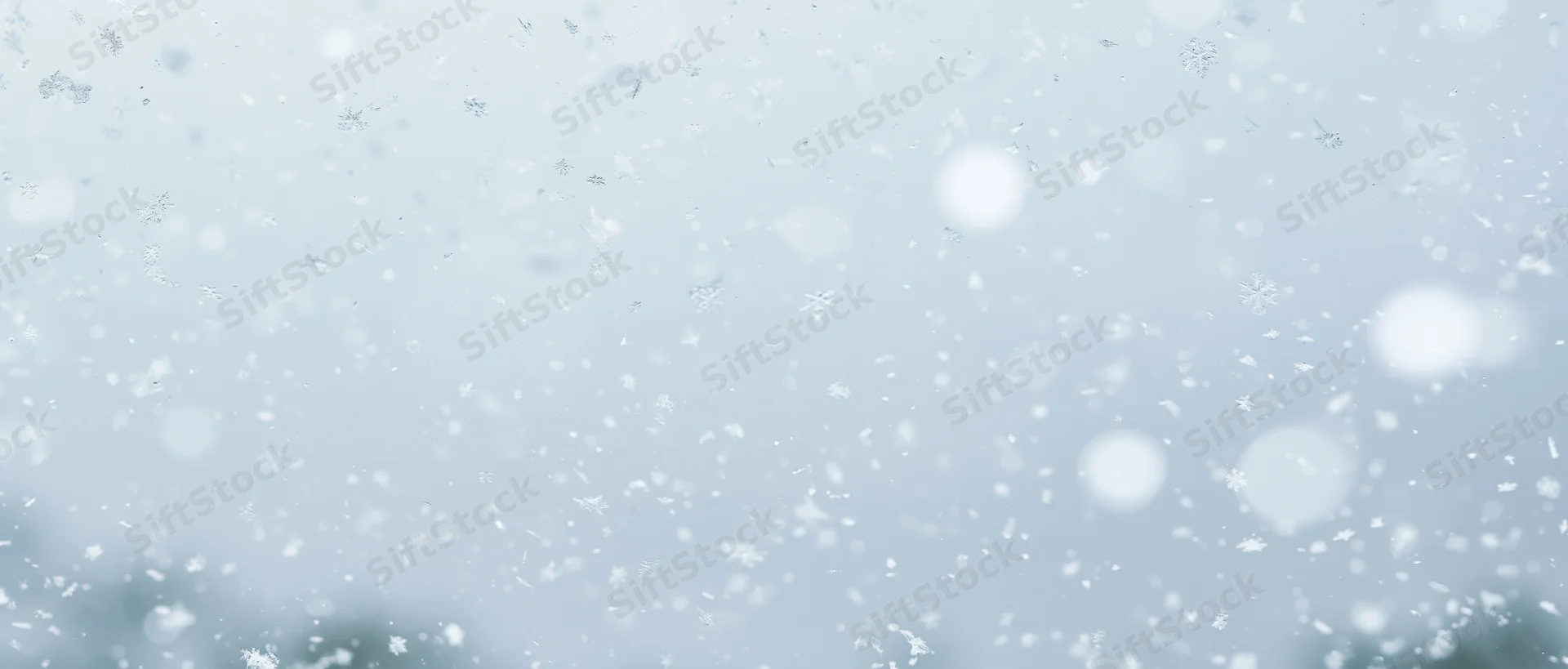 Falling snowflakes and soft bokeh particles in a winter sky