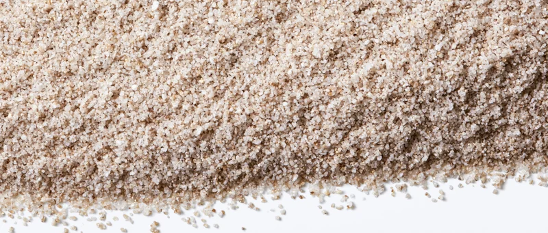 Fine dry sand granules spread across the upper frame tapering to a white background
