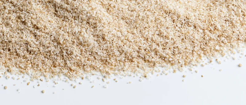 Fine dry sand granules spread across the upper frame tapering to a white background