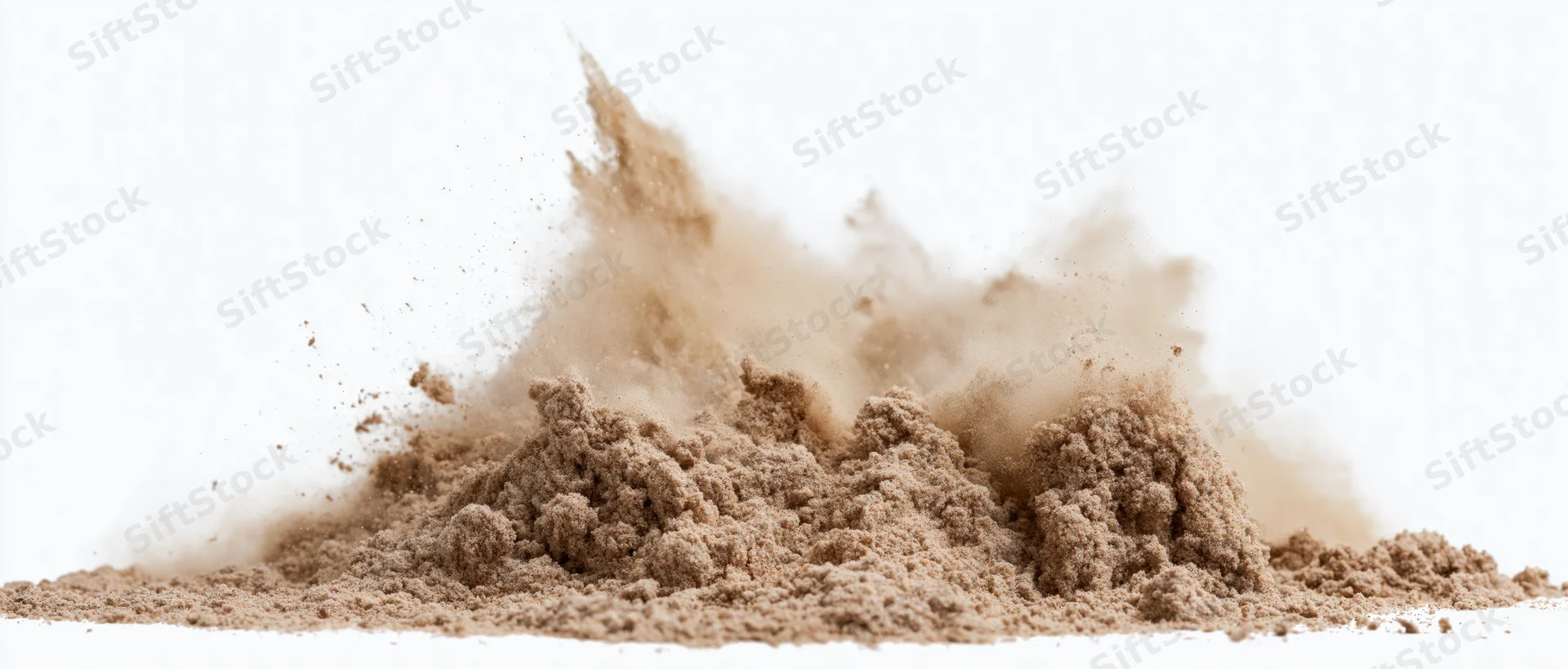 Fine dry sand bursting into airborne particles against white background