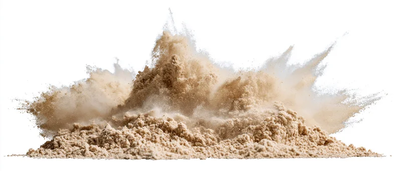 Fine dry sand exploding in mid-air with particles suspended in motion against white background