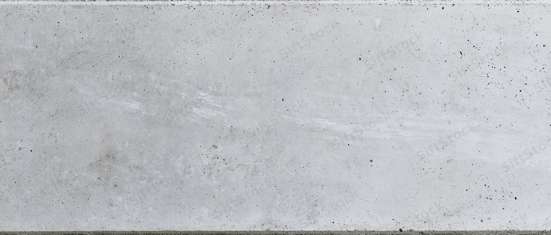 Flat concrete wall surface filling the frame with visible texture and speckles