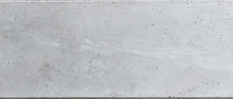 Flat concrete wall surface filling the frame with visible texture and speckles