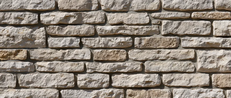 Flat exterior wall covered in irregularly sized cut sandstone blocks
