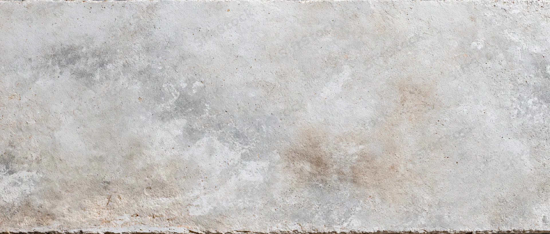 Close-up of a weathered concrete wall surface with rough texture and neutral tones