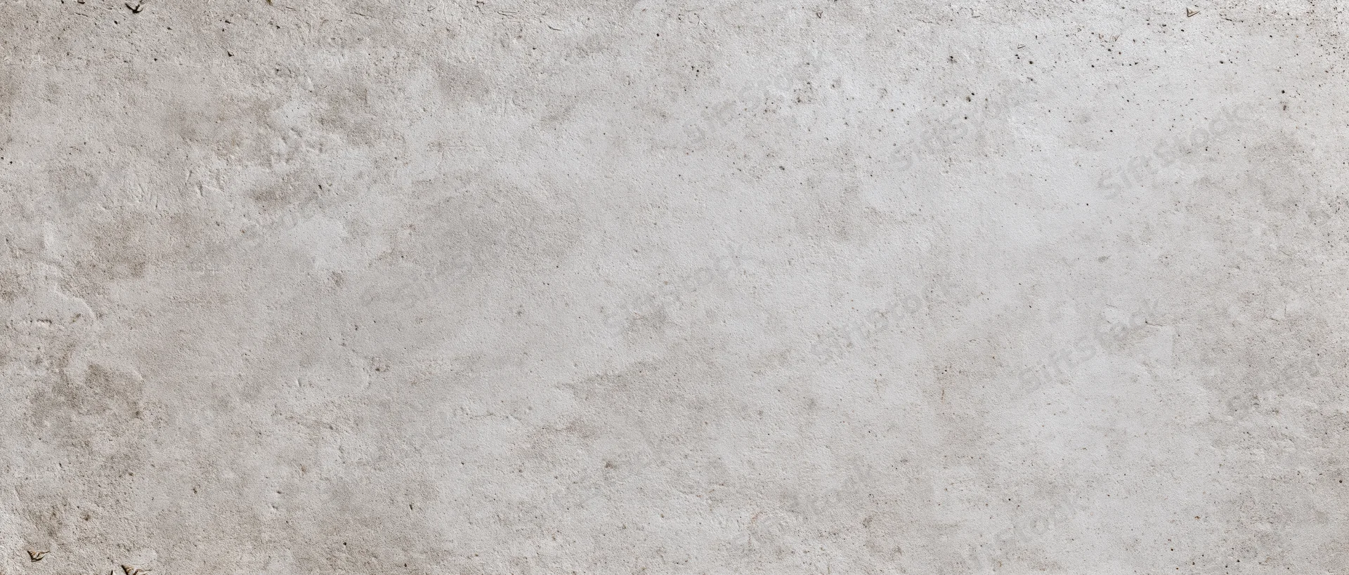 Close-up of a textured concrete wall surface with natural imperfections and subtle gray tones