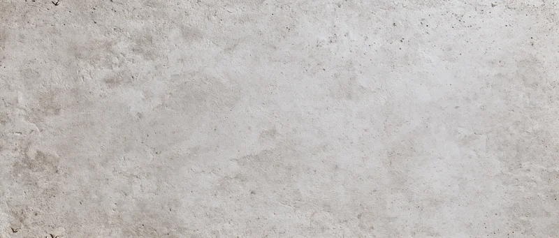 Close-up of a textured concrete wall surface with natural imperfections and subtle gray tones