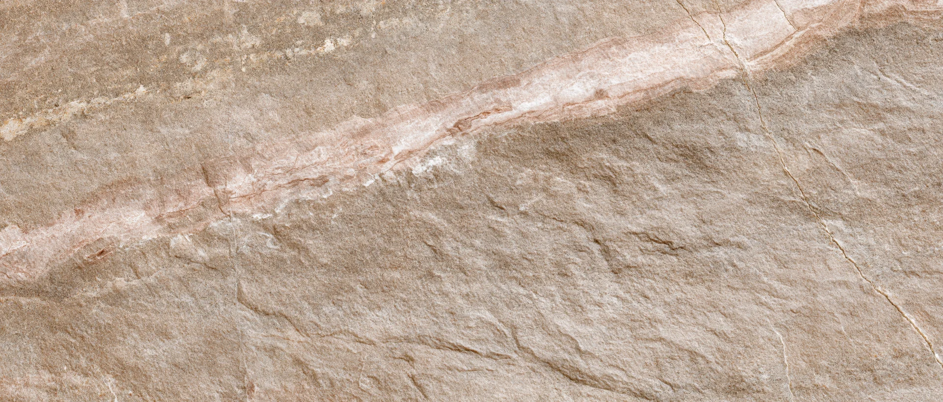 Close-up of a polished stone tile surface with natural veining and earthy tones