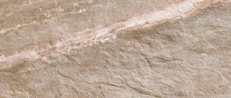 Close-up of a polished stone tile surface with natural veining and earthy tones