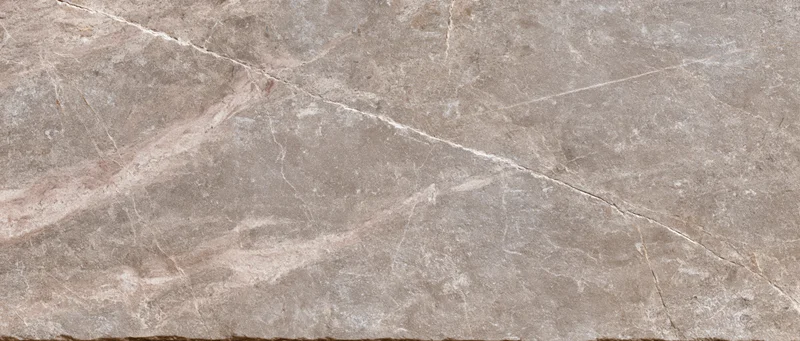 Close-up of polished stone tile surface with natural veining and earthy tones