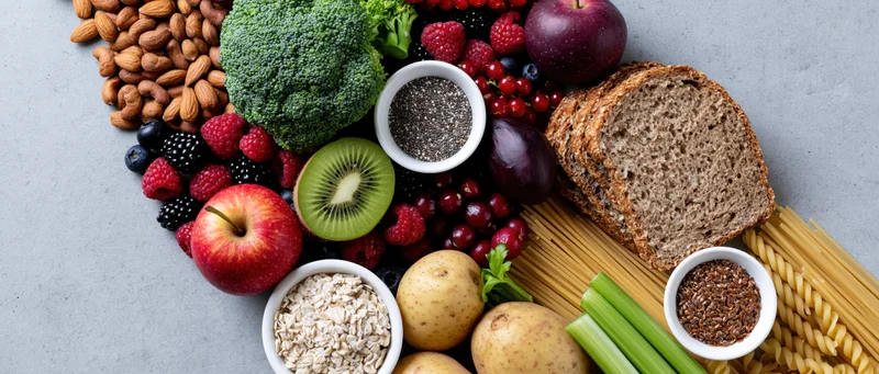 Assorted healthy foods arranged in a flat lay on a gray surface with copyspace on the left