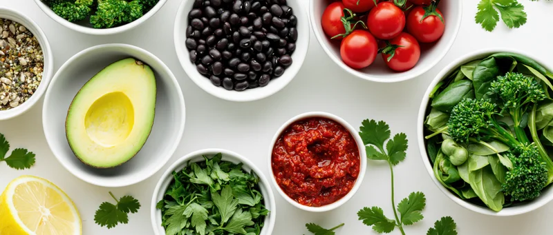 Fresh salad ingredients arranged in white ceramic bowls on a flat surface