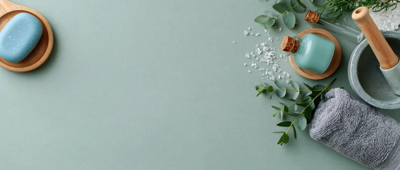 Spa and skincare items arranged on right side of mint green surface with copyspace on left