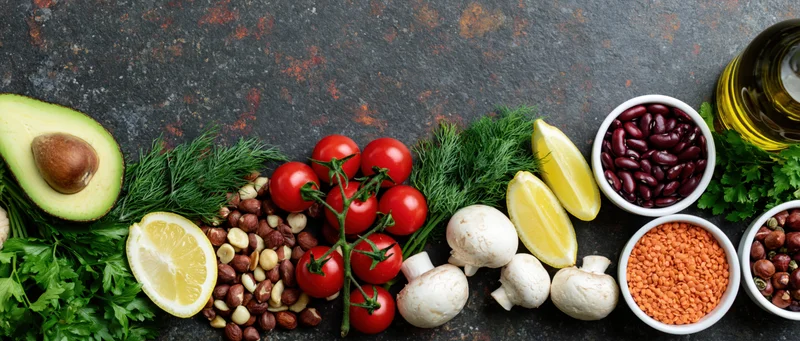 Whole foods arranged in a flat lay along a dark stone surface