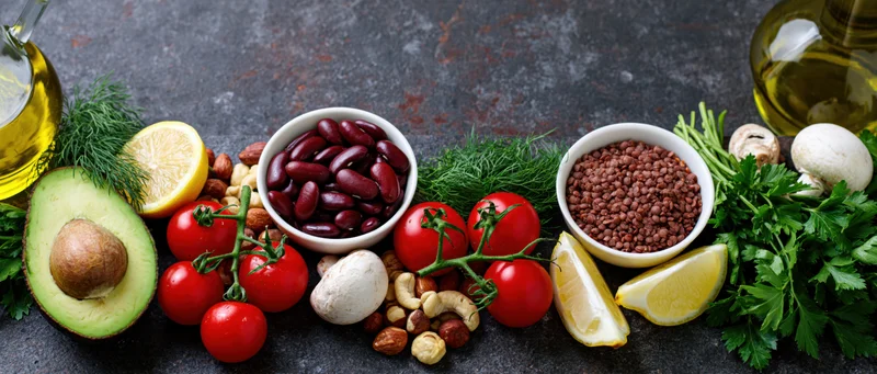 Whole foods arranged in a flat lay on a dark rustic surface