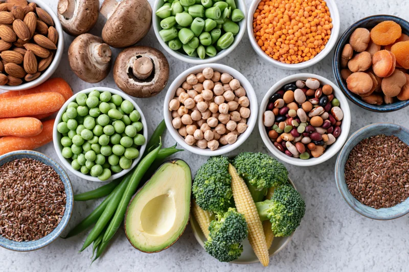 Assorted whole foods arranged in bowls and on a countertop in a flat lay overhead view