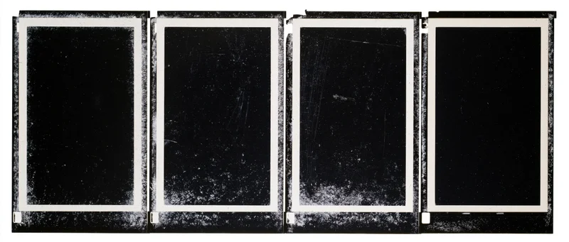 Four black film negative frames arranged side by side in a horizontal strip