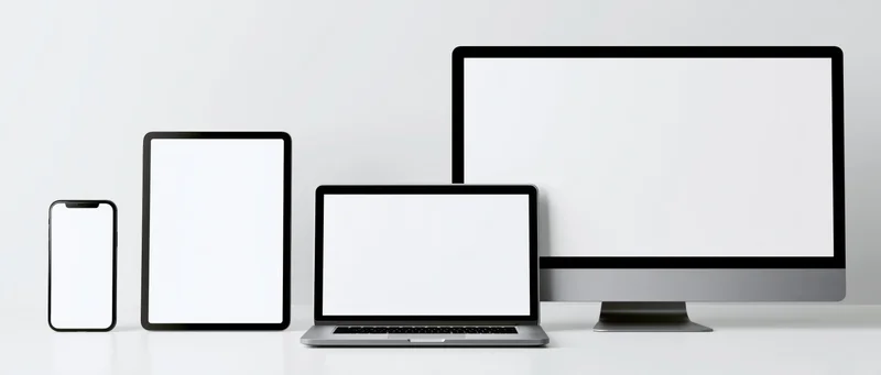 Four blank-screen devices arranged in a row on a white surface
