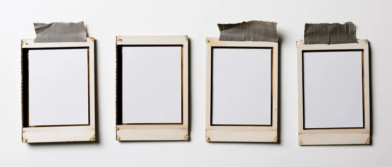 Four blank instant photo frames arranged in a row on a white wall