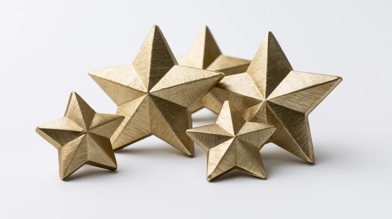 Metallic gold star decorations arranged in a loose cluster on a white surface