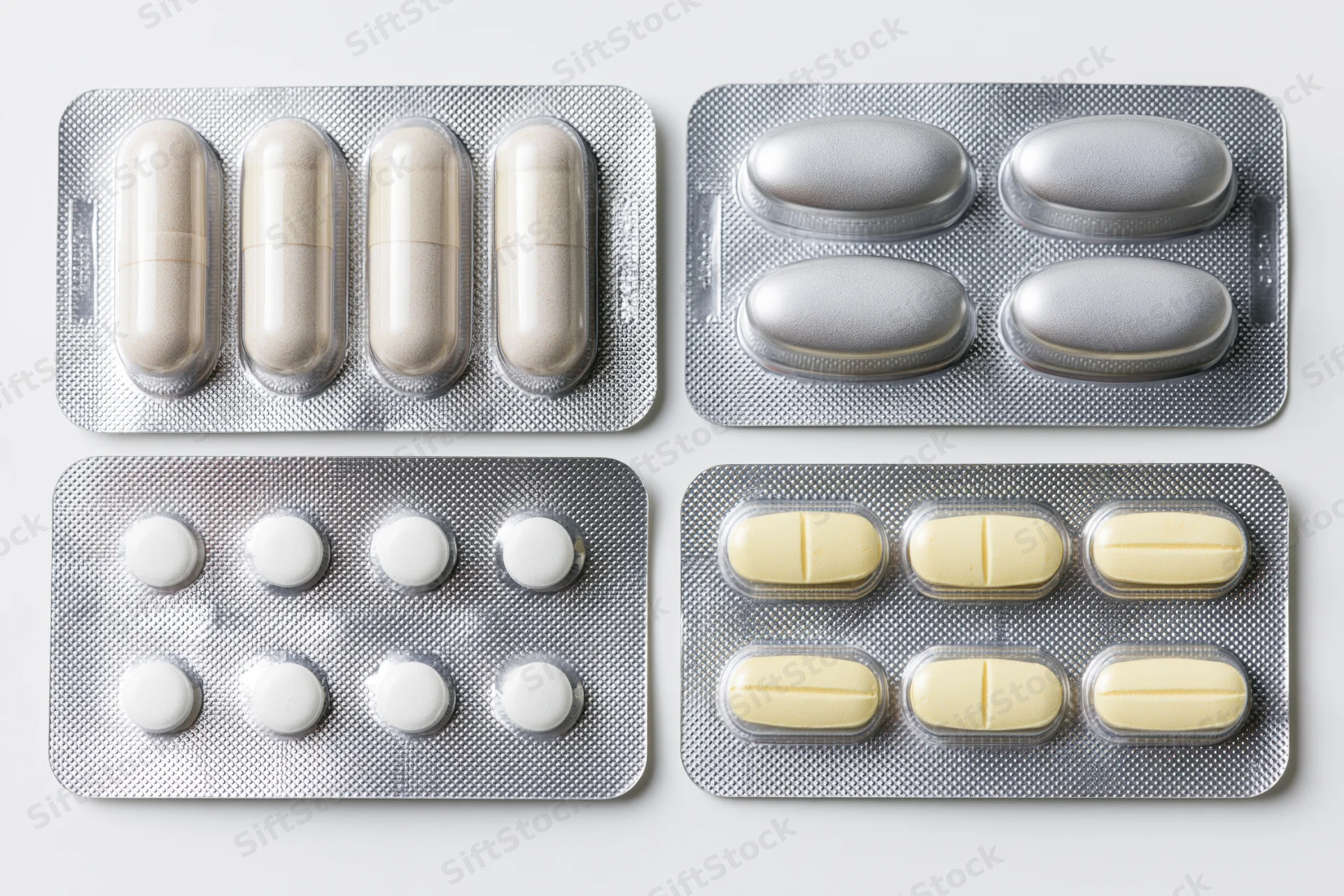 Four pharmaceutical blister packs arranged in a two-by-two grid on a white surface