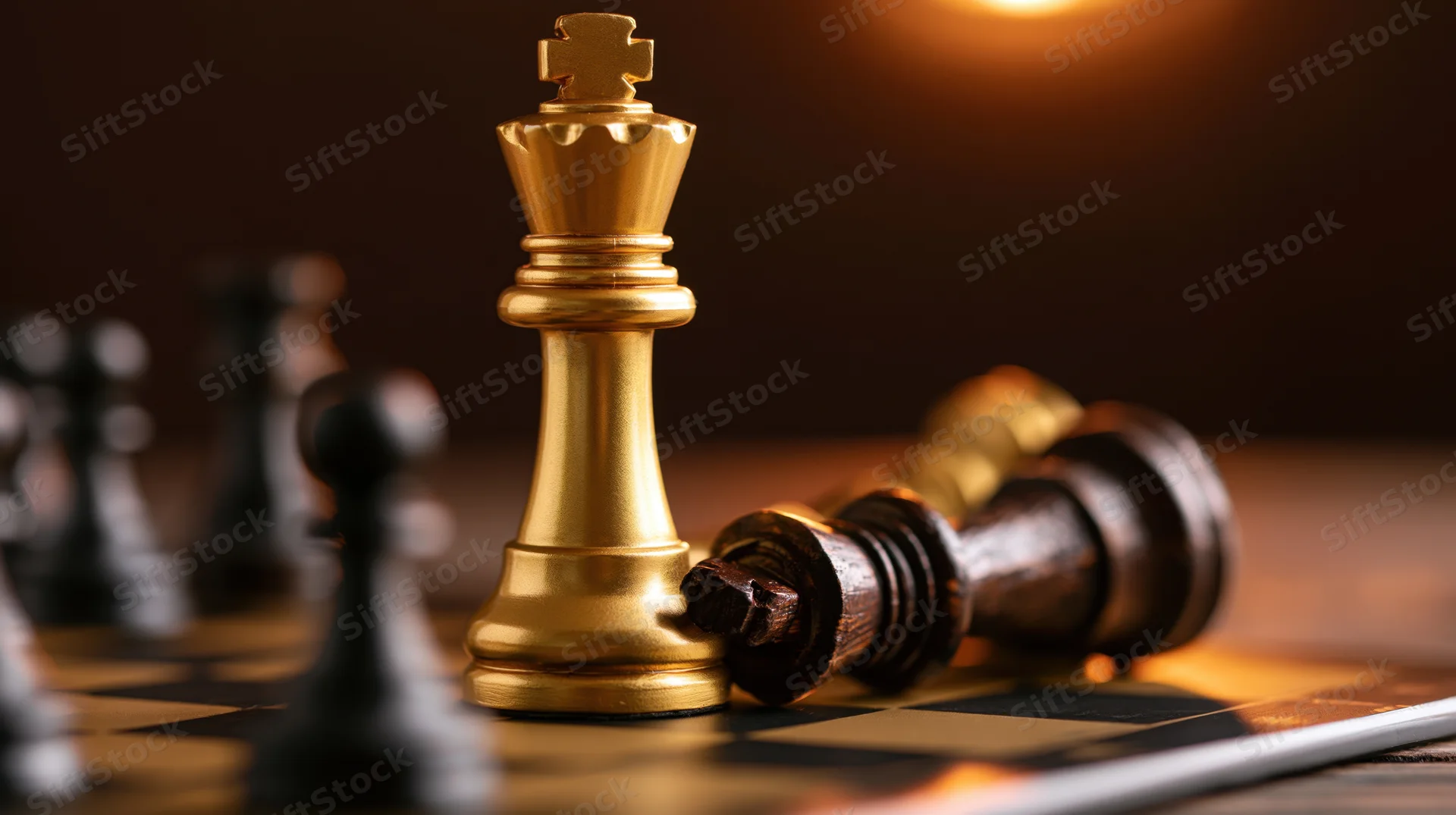 Gold chess king standing upright beside a fallen dark king on a chessboard under warm light