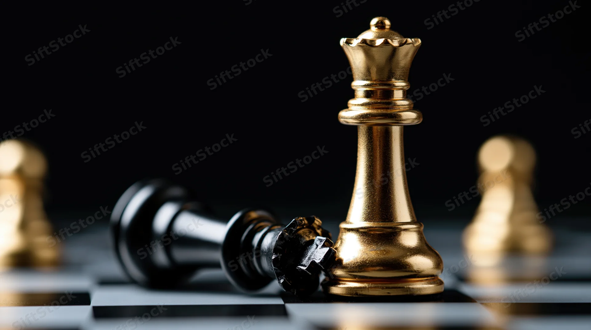 Gold chess king standing upright over a fallen black king on a chessboard