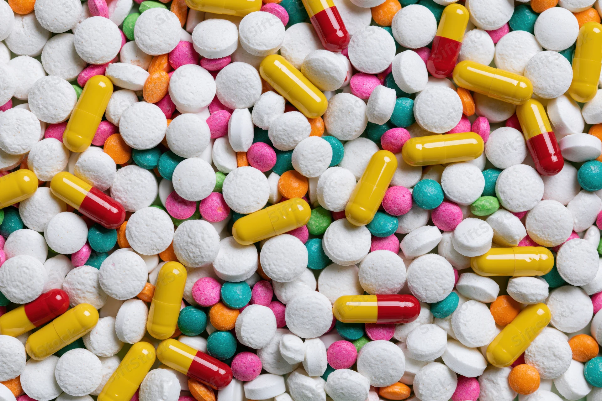 Assorted pharmaceutical pills and capsules in close-up overhead view
