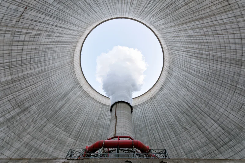 View from inside a cooling tower looking up at steam rising from the chimney