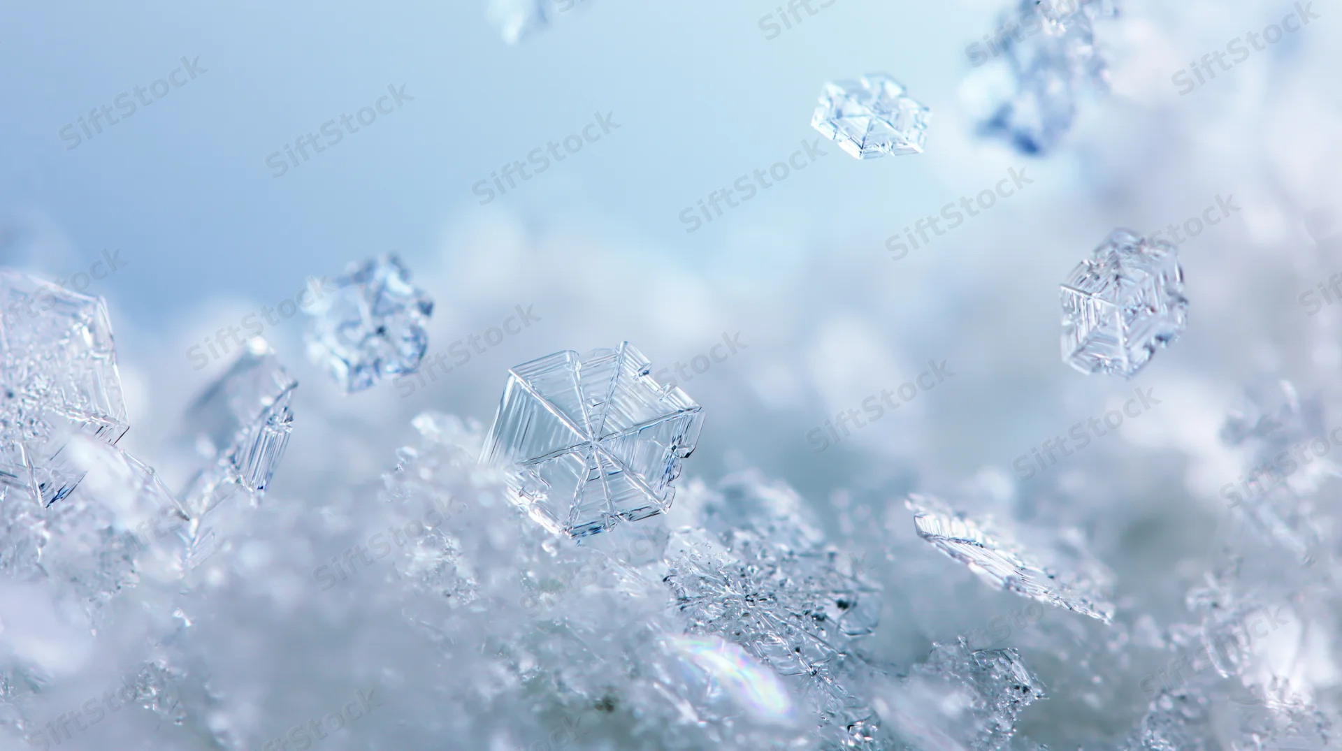 Macro closeup of ice snowflakes falling and layered on a frosty surface