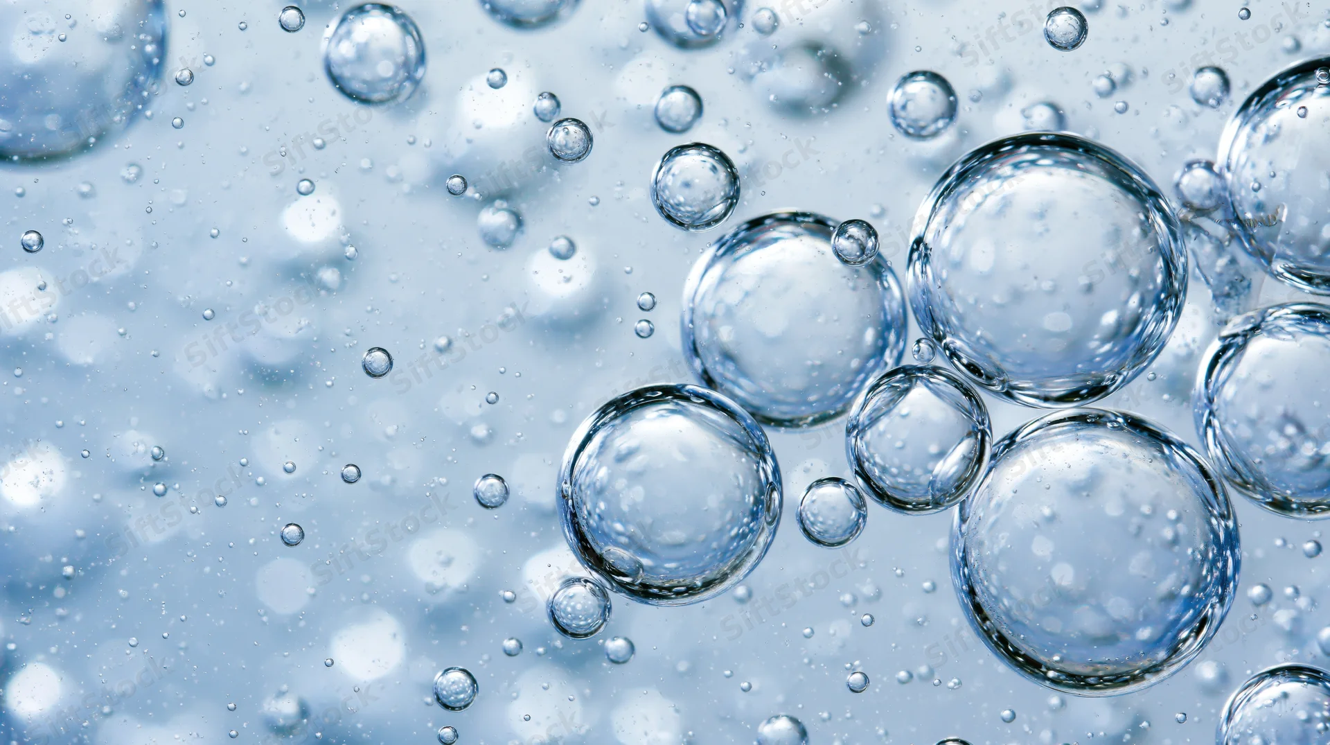 Close-up of translucent air bubbles suspended in clear liquid with light reflections and refractions