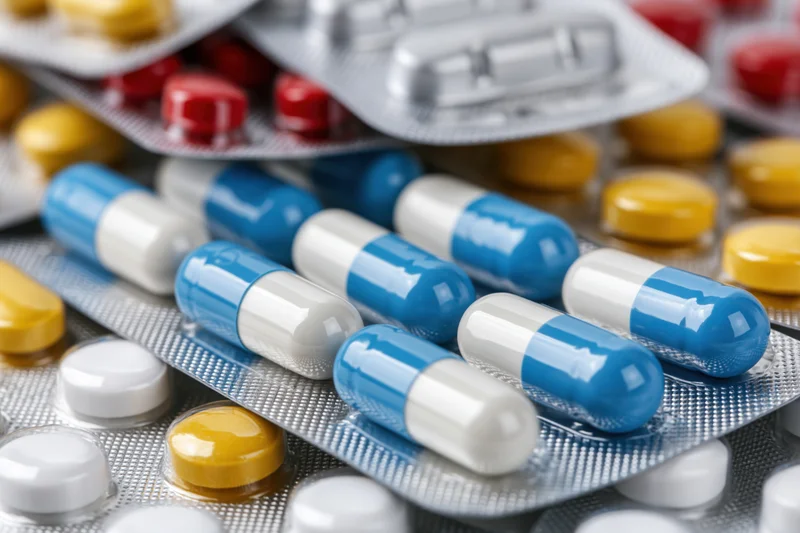 Assorted pharmaceutical pills and capsules in blister packs arranged in close-up view