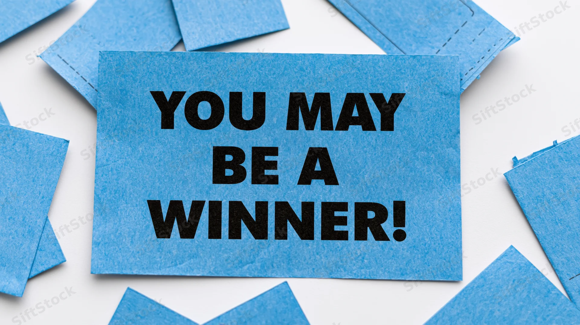Blue raffle ticket with bold text you may be a winner on white background surrounded by scattered tickets