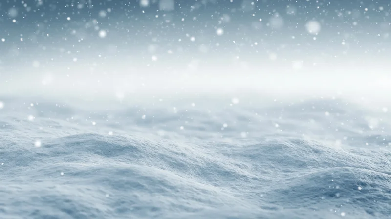 Snowy landscape under active snowfall with snowdrifts and overcast sky