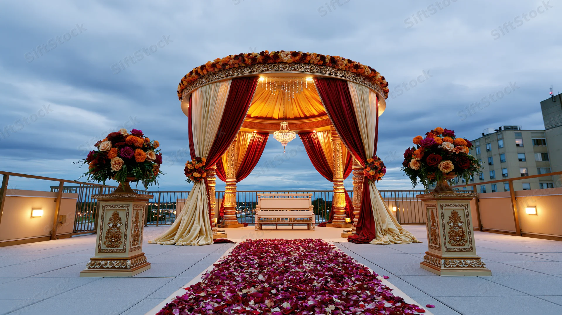 Ornate indian wedding mandap on rooftop terrace with floral decorations and petal aisle