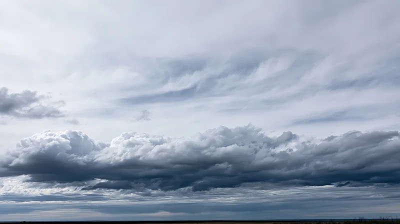Large billowing cumulus clouds filling the sky above a distant horizon