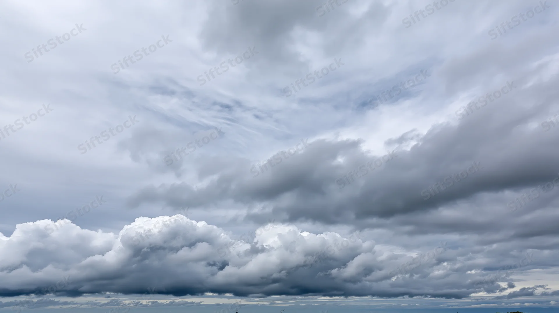 Overcast sky filled with large billowing cumulus clouds stretching across the horizon