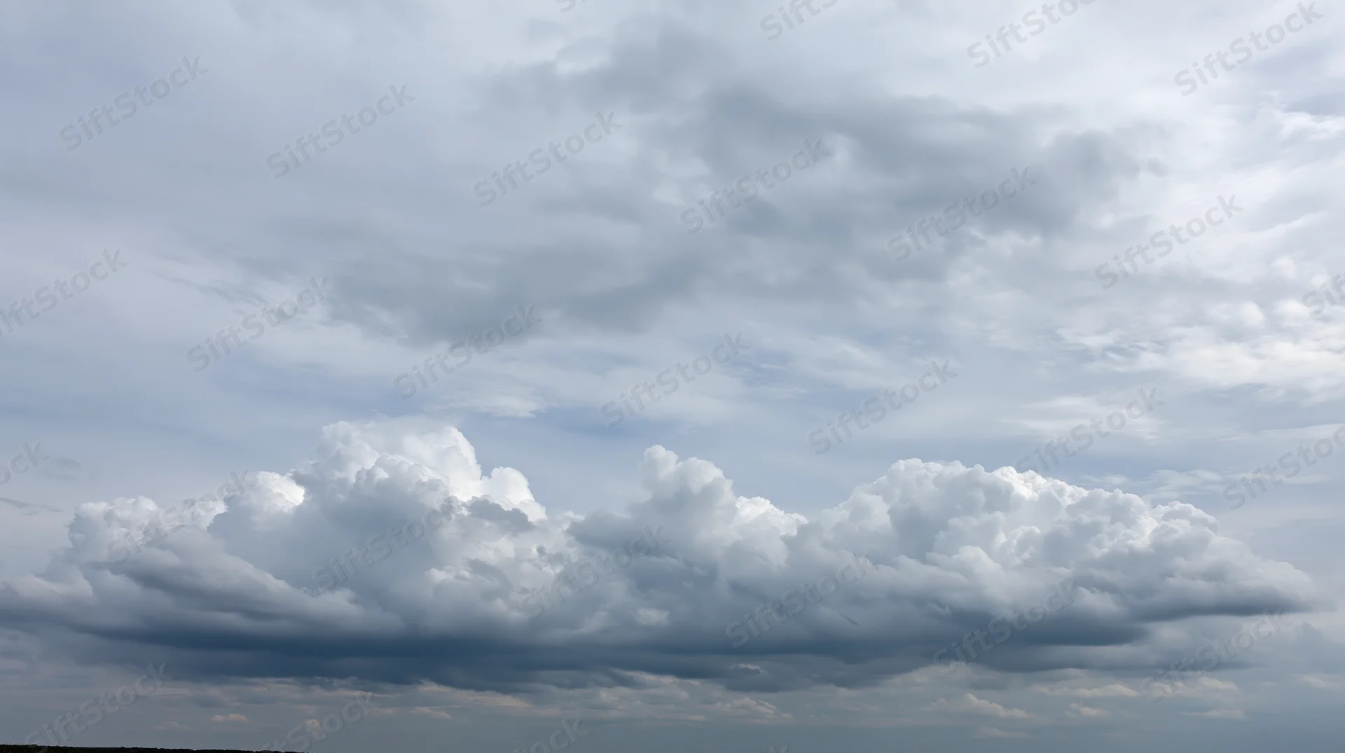Large billowing cumulus clouds filling the sky with overcast conditions