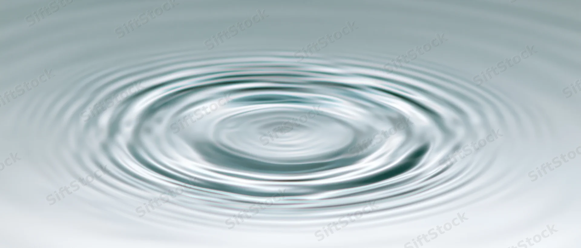 Circular ripples spreading across calm shallow water surface