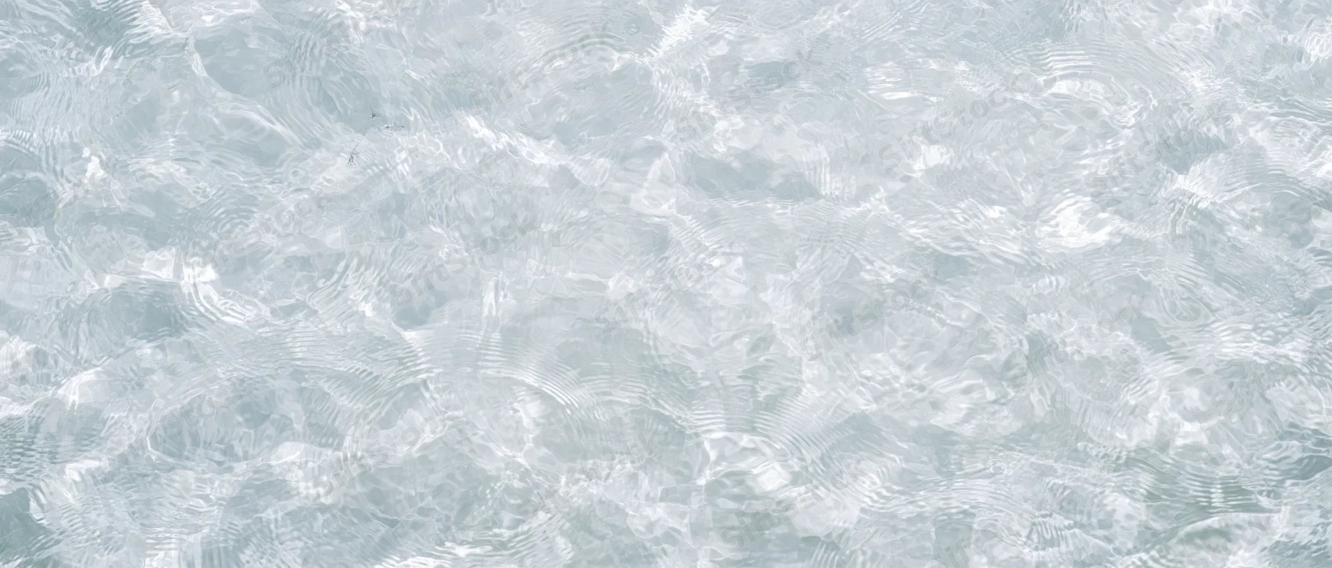 Overhead view of clear shallow water surface with ripples and light reflections