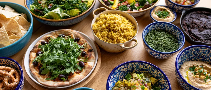 Overhead view of a shared meal with various dishes arranged on a wooden table
