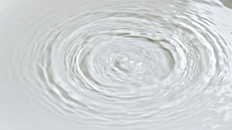 Overhead view of concentric ripples spreading across a shallow water surface