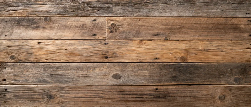 Reclaimed wood plank wall surface filling the frame with horizontal planks and visible grain and knots