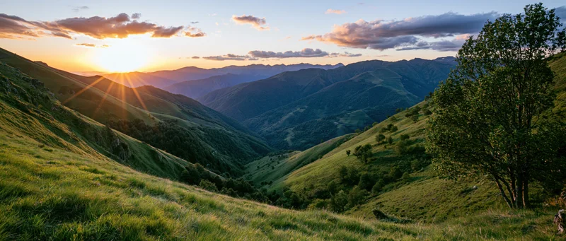 Rolling green hillsides at sunset in a mountain valley