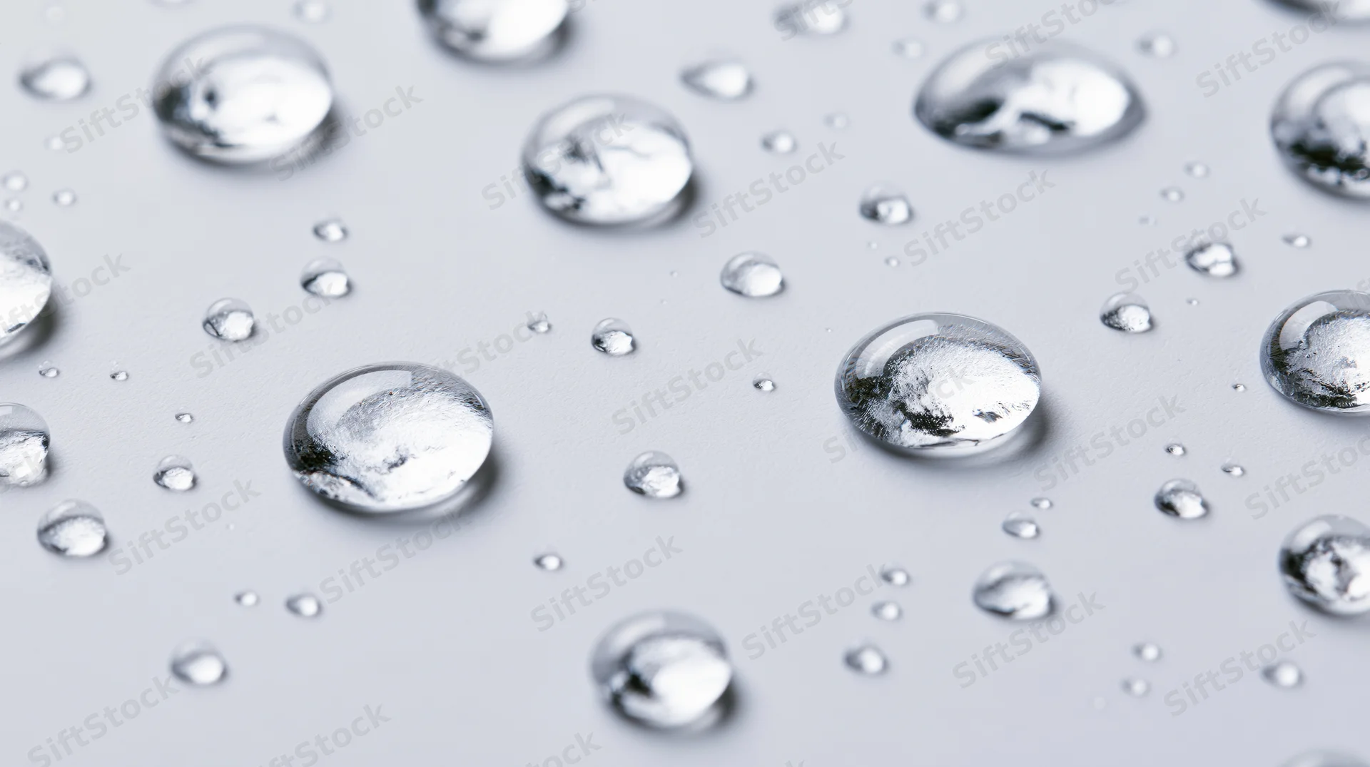 Water droplets scattered across a smooth white surface in closeup view