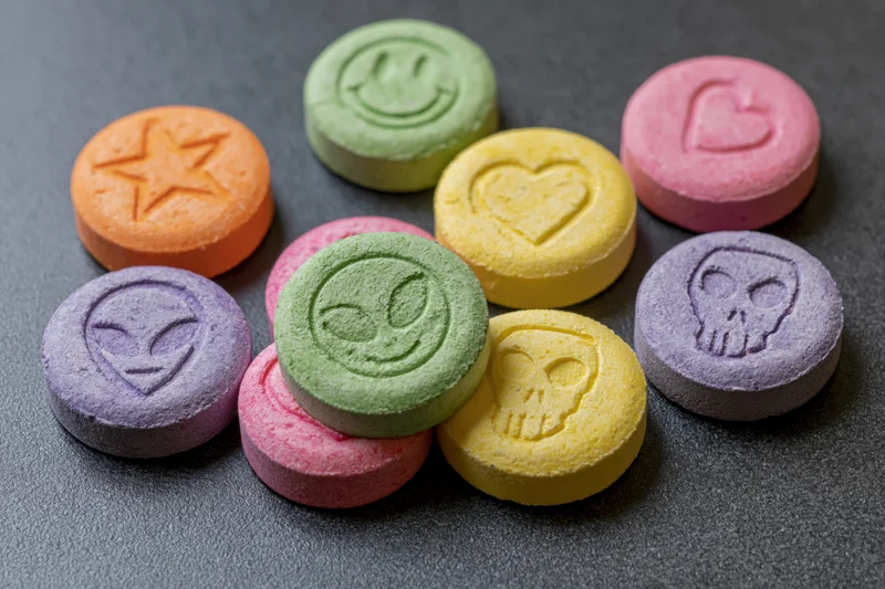 Colorful pressed tablets with symbols arranged on dark surface