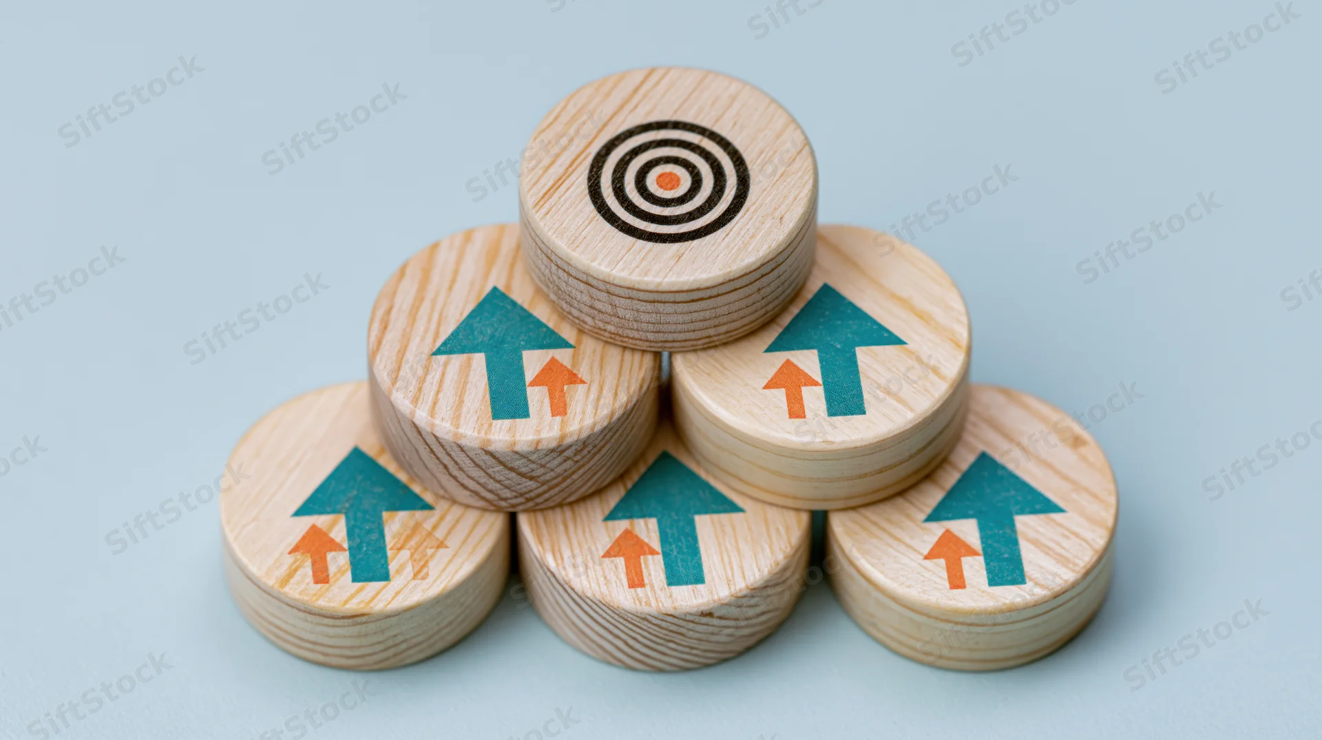 Wooden discs with arrows arranged in pyramid shape pointing toward target at top