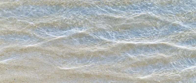 Shallow clear ocean water rippling over sandy seafloor