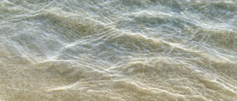 Shallow clear ocean water rippling over sandy seafloor